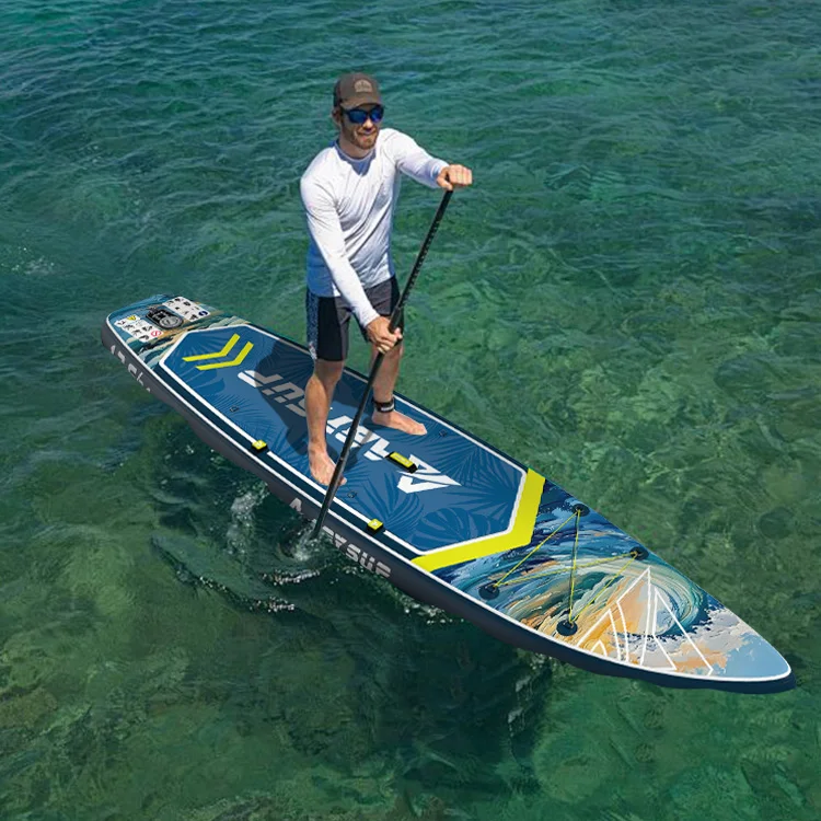 Person paddleboarding on a blue and yellow board in clear ocean water, wearing a white shirt, black shorts, and a cap.