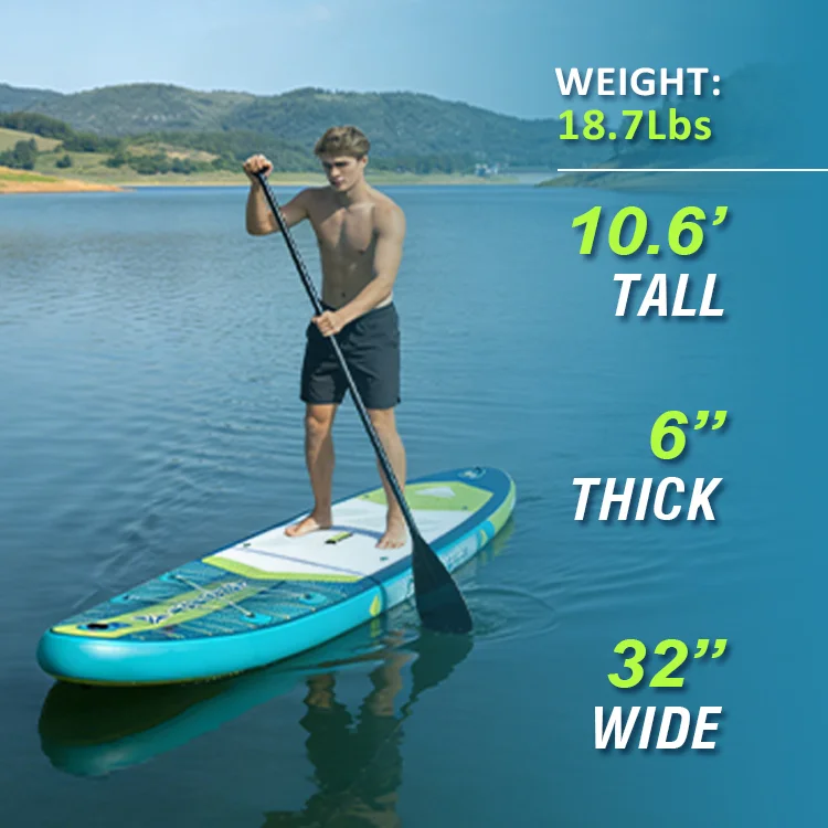 Man standing on a paddleboard on a lake holding a paddle. Paddleboard dimensions include tall, thick, and wide measurements.
