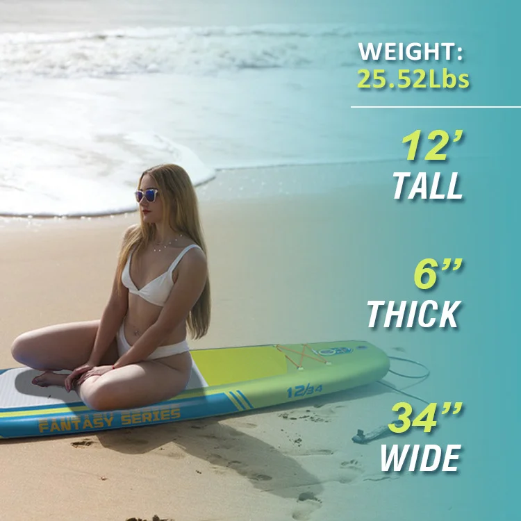Woman in white bikini sitting on a paddleboard labeled 'Fantasy Series' on a sandy beach with ocean waves in the background.