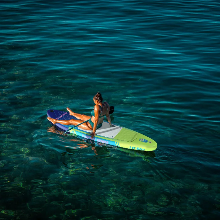 Woman in a swimsuit relaxing on a paddleboard in clear, turquoise ocean water, surrounded by a serene and calm environment.