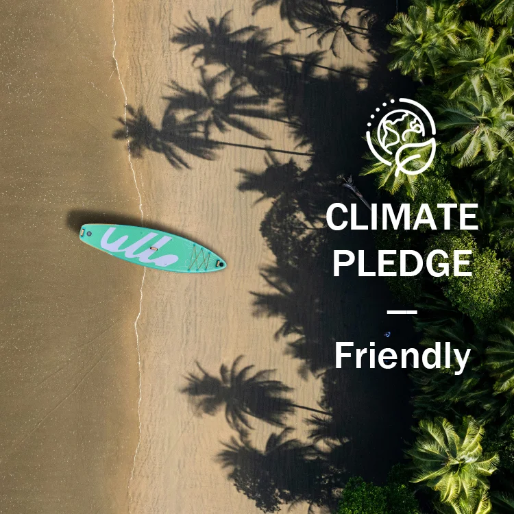 O plajă liniștită cu umbre de palmieri, cu o placă de paddle verde pe nisip. Textul spune „Climate Pledge Friendly” (Angajament pentru o comunitate prietenoasă cu clima).